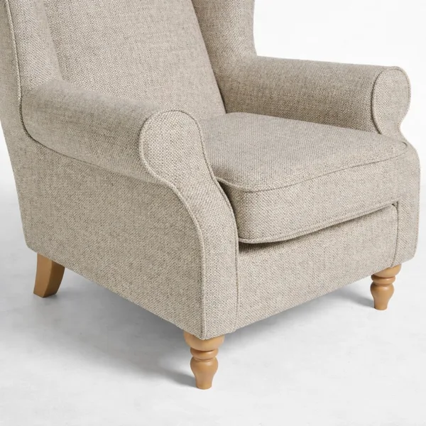 Beige wingback armchair with teakwood legs close-up showing rolled arms and seat cushion, INTERIORZE HERITAGEWING.