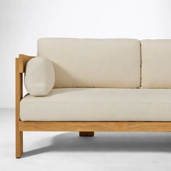 Close-up of teakwood sectional sofa arm with ivory upholstered cushion