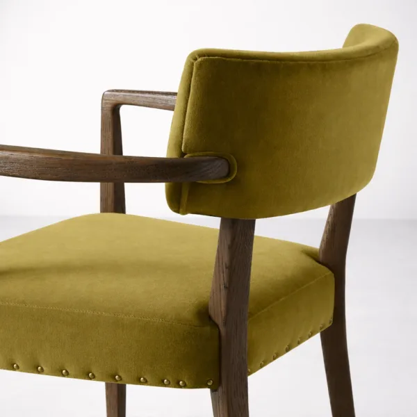 Close up of olive green upholstery and teakwood armrest on INTERIORZE dining chair