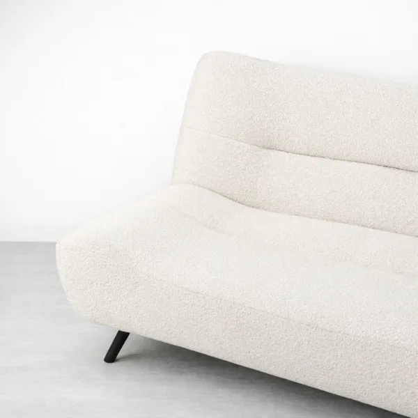 Side profile of cream bouclé sofa cum bed with black legs