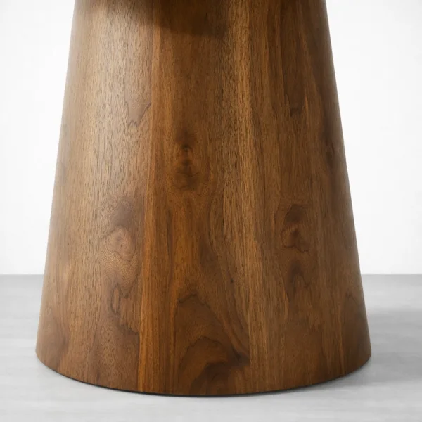 Close-up of teakwood pedestal base with walnut tone polish on Aurora dining table