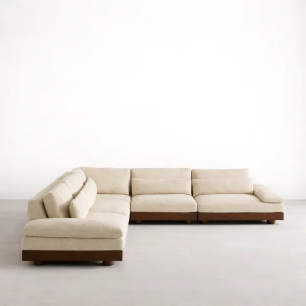 Corner view of L-shape sectional sofa with teakwood base and ivory upholstery