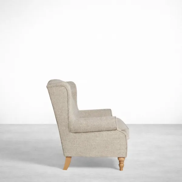 Beige wingback sofa side view showing winged high back and rolled arm profile
