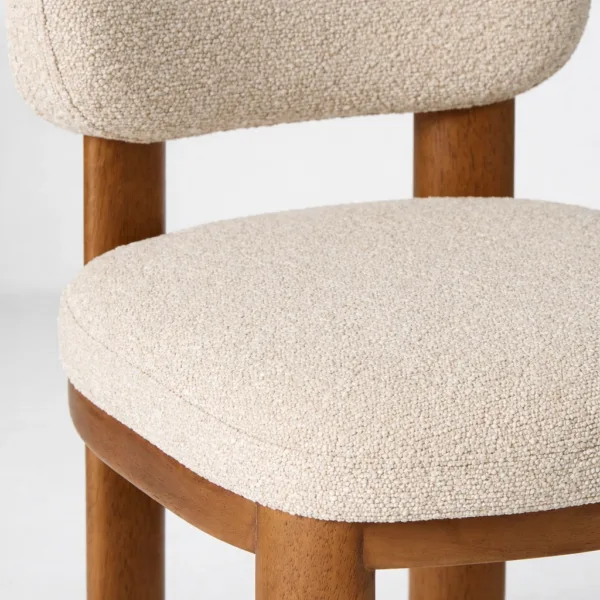 Close-up of ivory bouclé fabric upholstery on dining chair seat – INTERIORZE