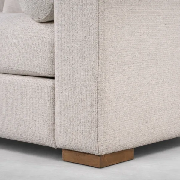 Beige sofa fabric and teakwood base close-up detail showing natural matte finish
