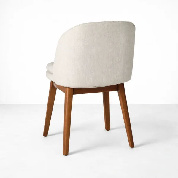 Upholstered teakwood dining chair back angle view ivory fabric upholstery