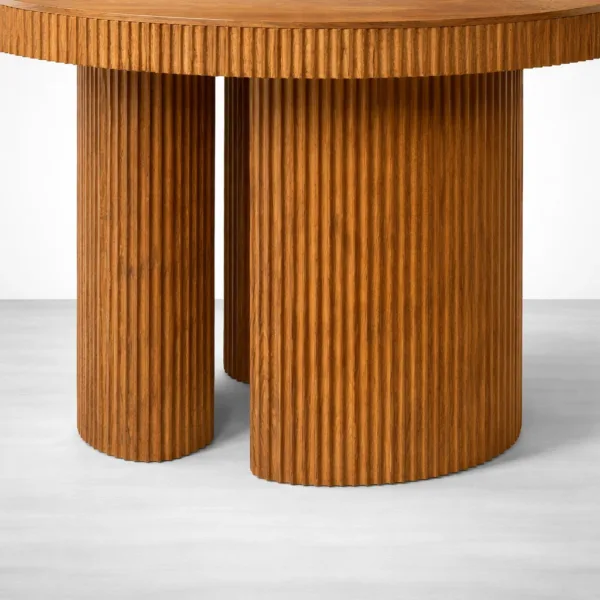 Fluted teakwood base detail on round fluted teakwood dining table