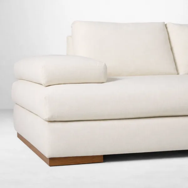 Ivory linen L shape sectional sofa wooden plinth base detail by INTERIORZE