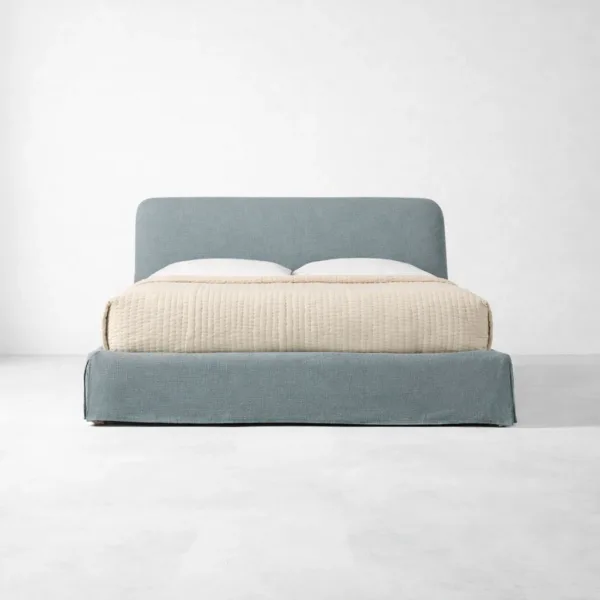 Skirted upholstered bed in steel blue with curved headboard by INTERIORZE