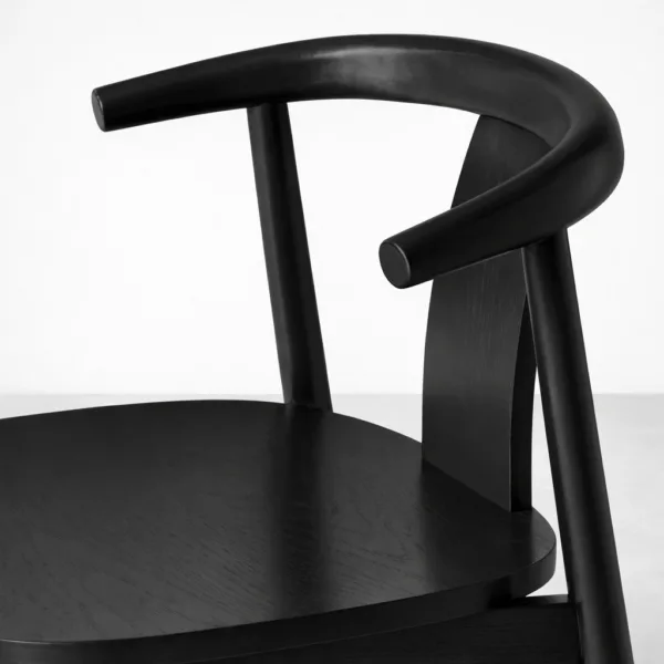 Close up of teakwood dining chair curved arm and backrest