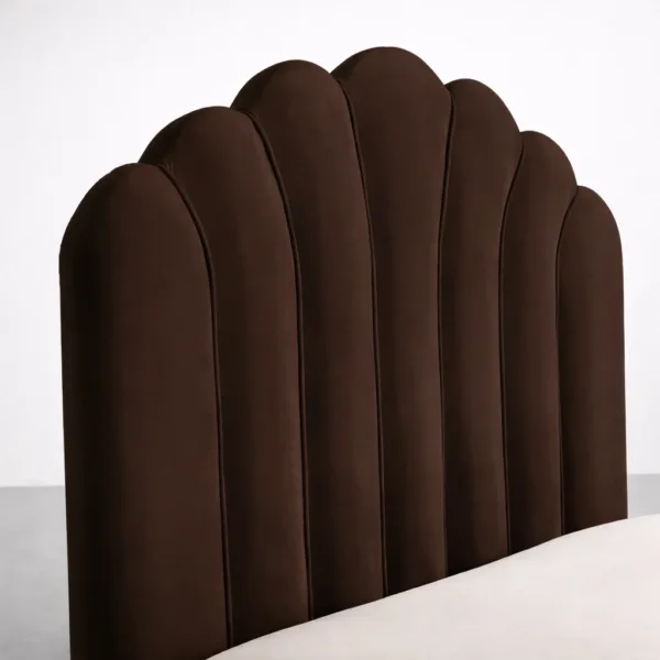 Close-up of scallop panel headboard on brown upholstered bed showing vertical sections