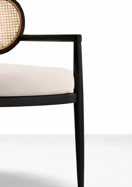 Close-up of black polished teakwood arm and beige seat with cane backrest detail