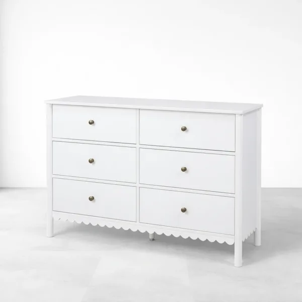 close-up of scalloped apron base on white teak wood chest of drawers