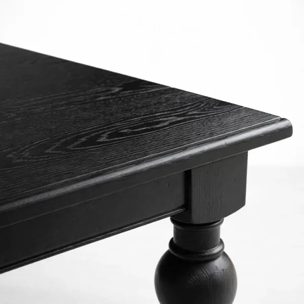 Angled view of INTERIORZE Noir Heritage solid wood dining table with turned legs