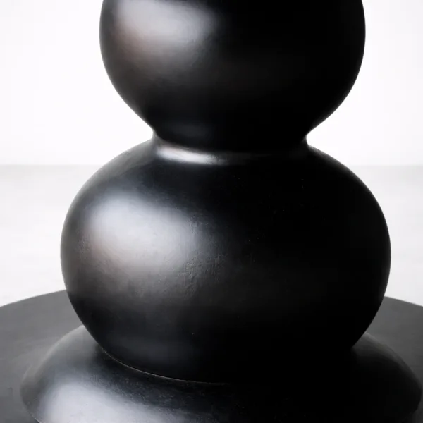 Close-up of sculptural pedestal base on INTERIORZE Obsidian Orb round dining table