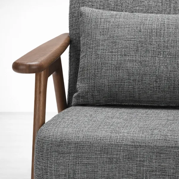 Close-up of grey fabric upholstery and teakwood armrest with walnut polish