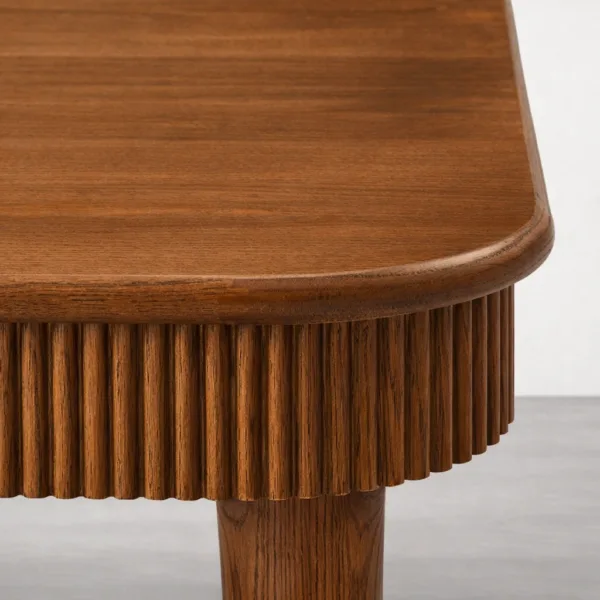Close-up of rounded corner and fluted apron detail on INTERIORZE Elvora teakwood dining table