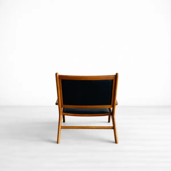 INTERIORZE Orion teakwood upholstered lounge arm chair with black seat and backrest in warm teak finish