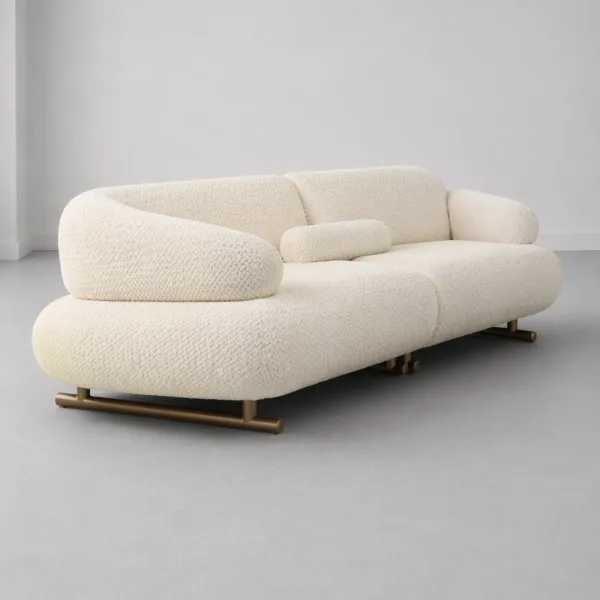 INTERIORZE cream boucle sofa with sculpted curved arms and brass-toned base