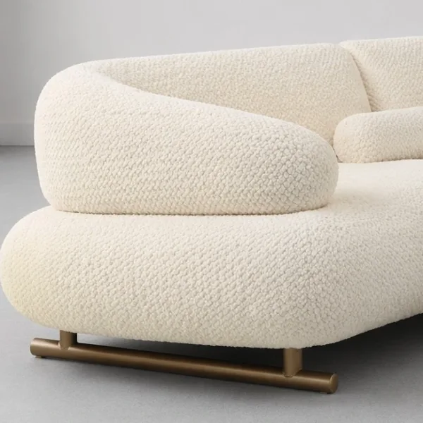INTERIORZE cream boucle sofa with sculpted curved arms and brass-toned base